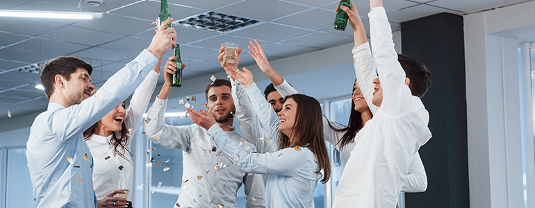 Trabajadores celebrando sus logros en la oficina demostrando el sentido de pertenencia que hay en la empresa